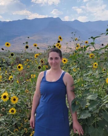 Yin Yoga instructor standing in front of flowers